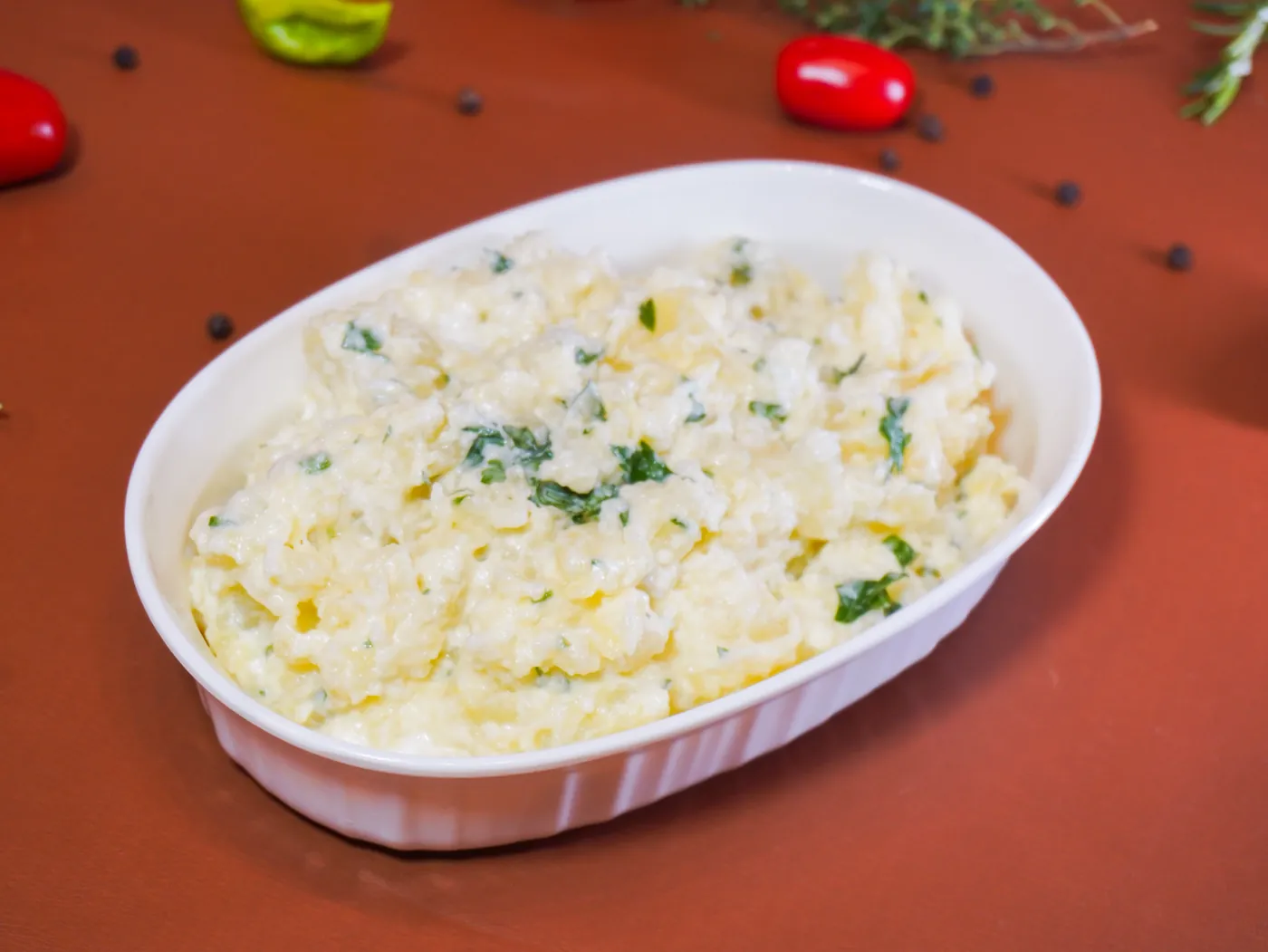 Maionese da casa em travessa branca, salpicada de cheiro-verde