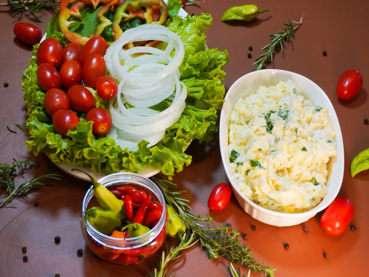 Salada verde, maionese e conserva de pimenta servidas na mesa
